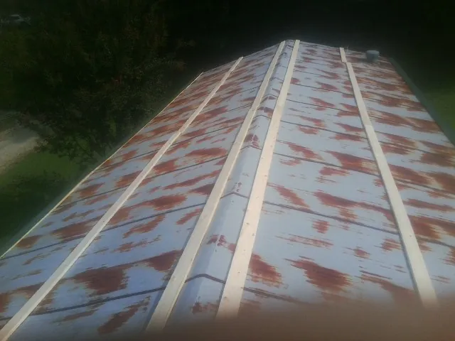 Rusted metal roof panels with new wood purlins before replacement — Storm Damage Roof Repair in Corapeake by Roofing Brothers