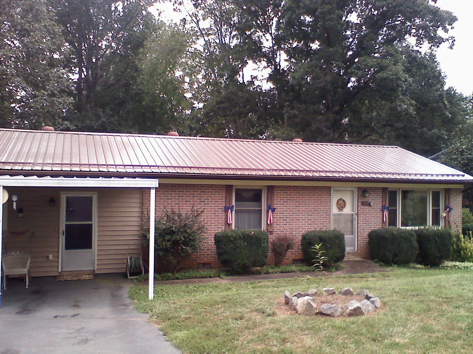 Bronze metal roof and carport on a brick ranch home — Roof Repair work by our crew in Corapeake